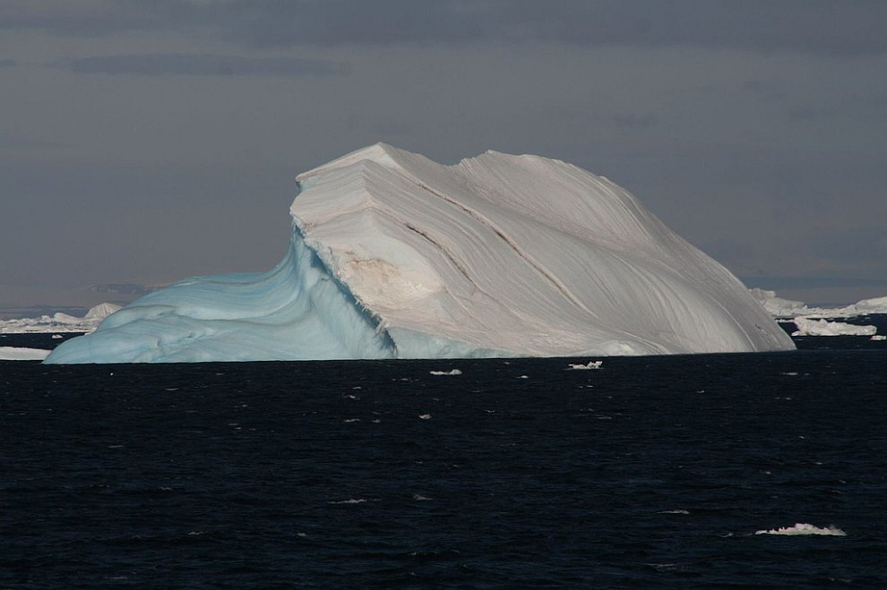 Голубой с одной стороны айсберг
