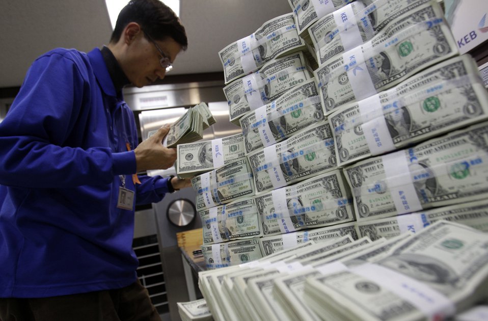 Банковский служащий сортирует пачки с американской валютой