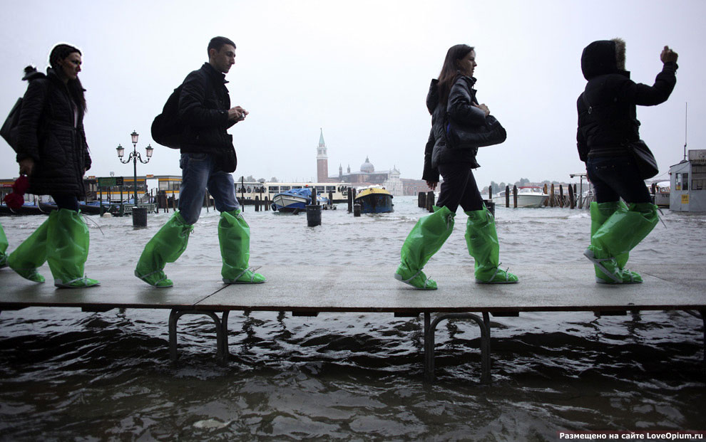 Время от времени Венецию затапливает и тогда туристам приходится ходить по городу в специальной одежде по специальным временным мостикам