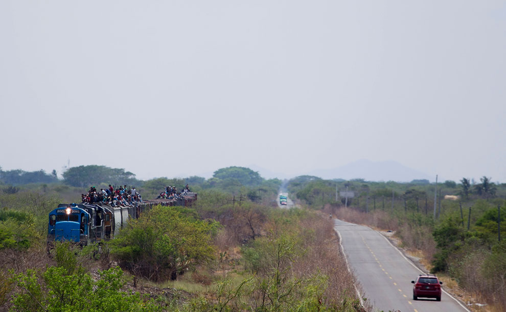 Мигранты едут на крыше поезда, направляясь к американо-мексиканской границе