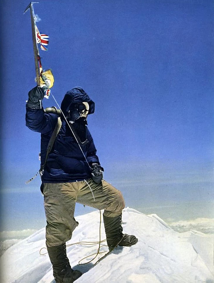 Почти двухметрового роста новозеландец Эдмунд Хиллари сфотографировал малорослого шерпа на снежном куполе с поднятым ледорубом, украшенным флажками ООН, Великобритании, Непала и Индии