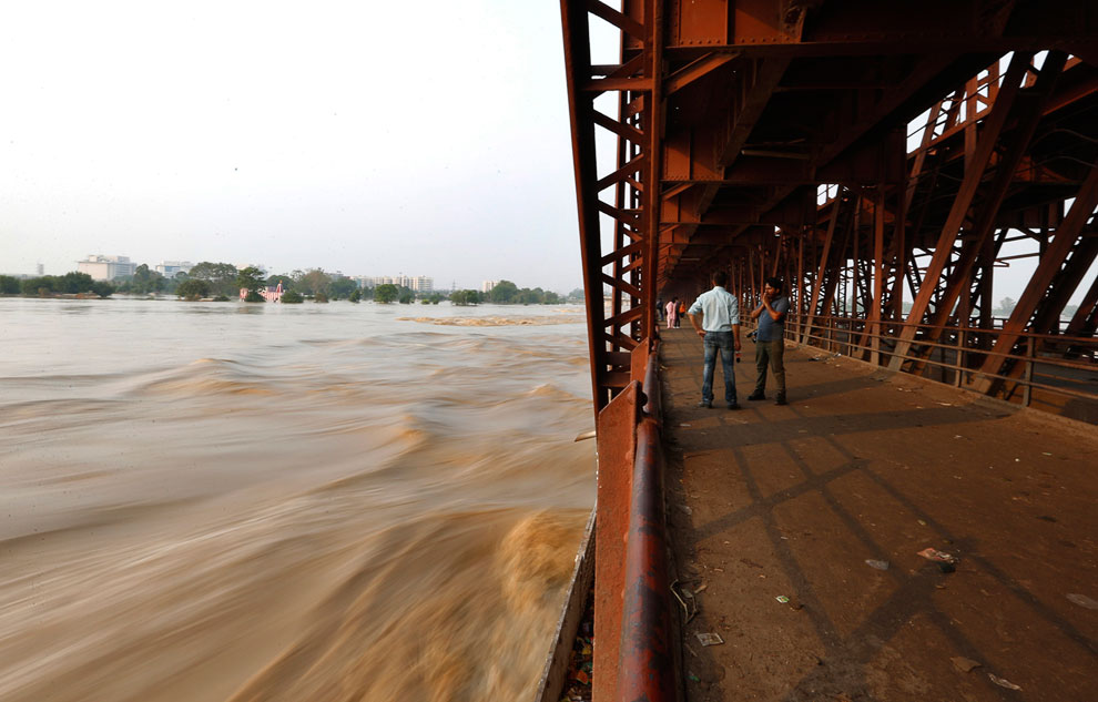 Опасно высокий уровень воды почти касается моста на реке Ямуна в Нью-Дели, Индия