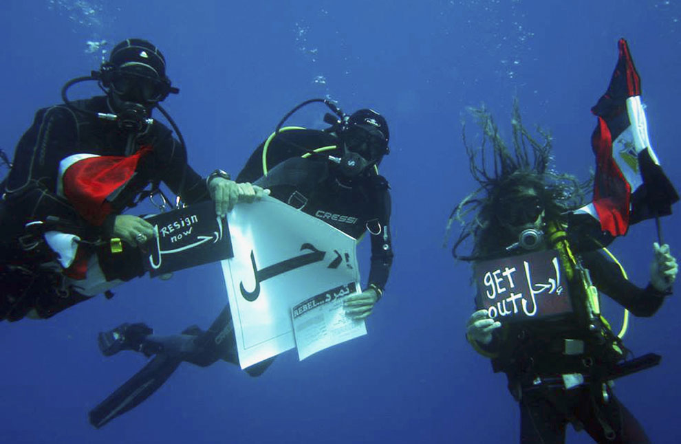 Некоторые протестуют даже под водой. На фотографии: аквалангисты держат плакат «Уходи». Шарм-эль-Шейх