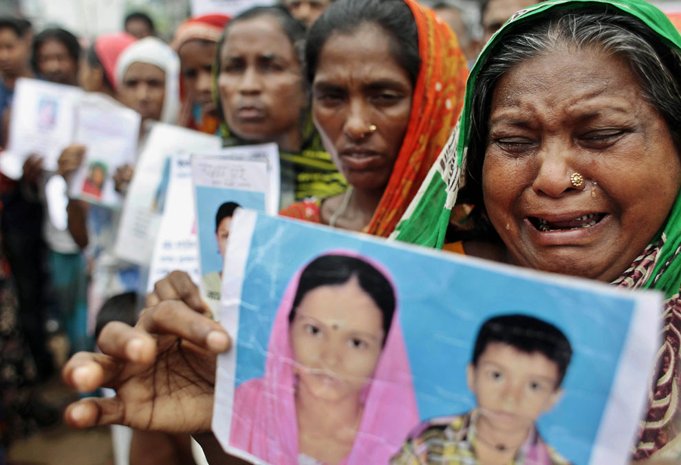 Женщины с фотографиями погибших и пропавших без вести родственников требуют компенсации от властей и владельцев рухнувшей фабрики, Бангладеш