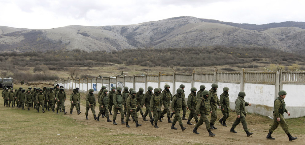 Люди у униформе, которых считают российскими военнослужащими, около военной базы в селе Перевальное возле Симферополя