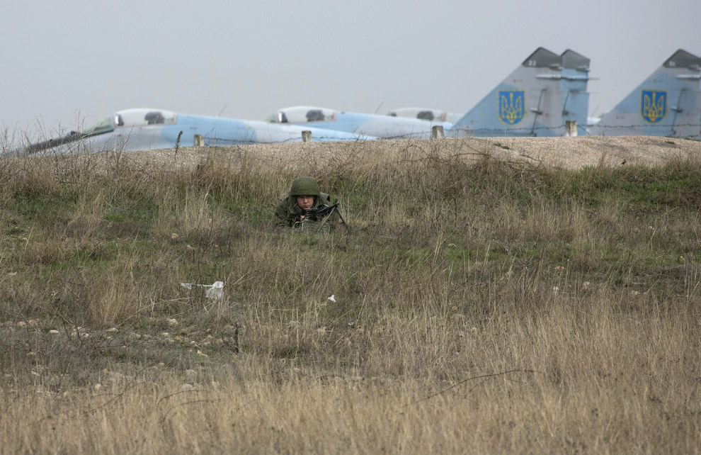 Русский солдат на фоне украинских истребителей в аэропорту Бельбек, Крым