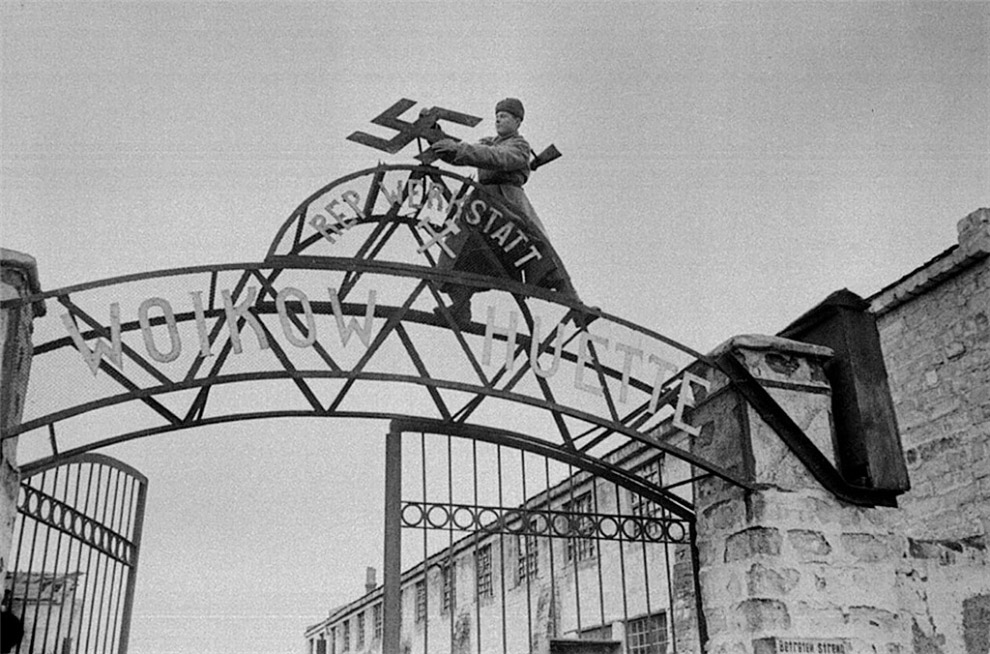 Советский солдат срывает нацистскую свастику с ворот  металлургического завода им. Войкова в освобождённой Керчи