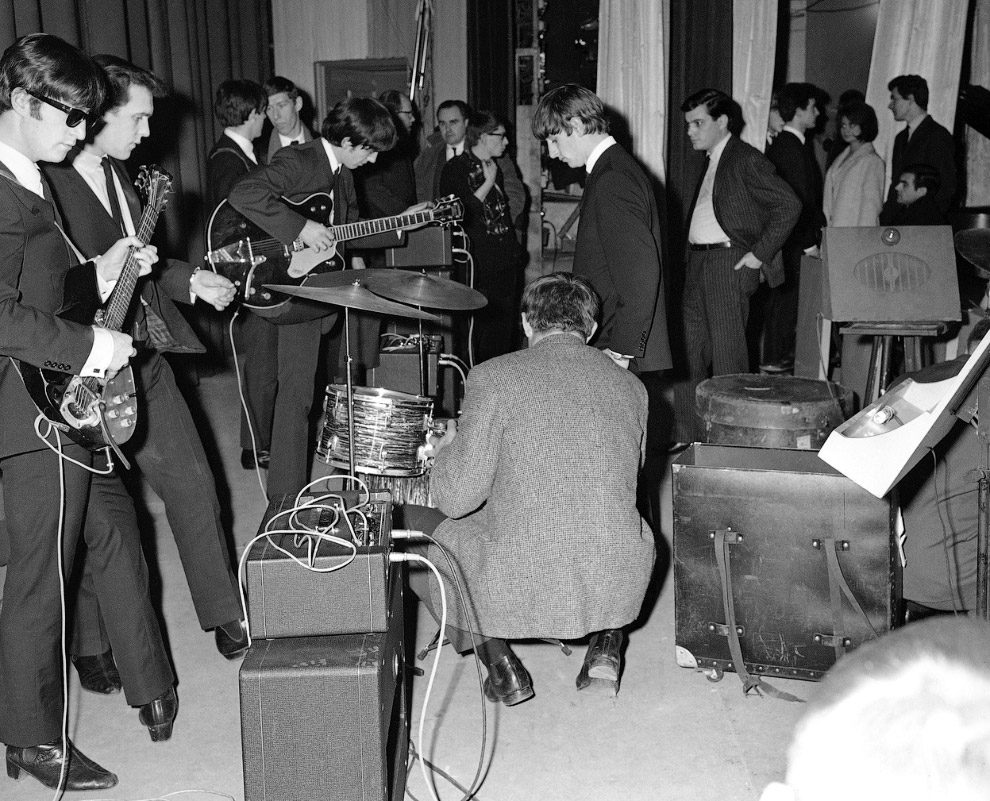 Слева — Джон Леннон, по центру с гитарой — Джордж Харрисон и Ринго Старр