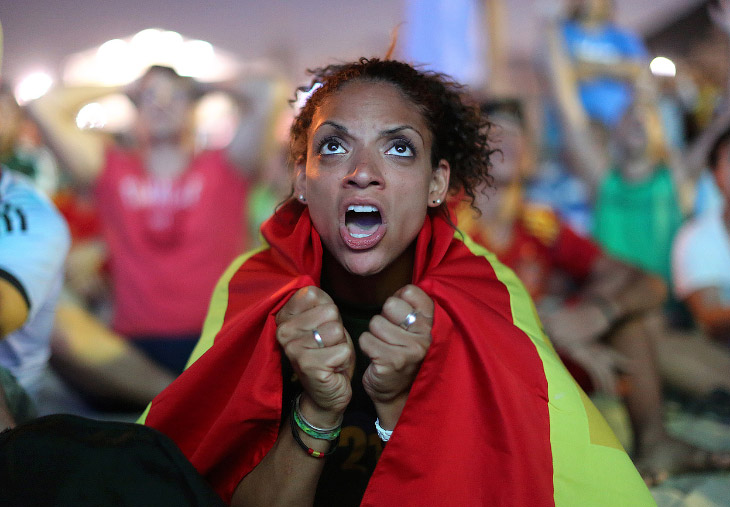 Испанская болельщица смотрит игру Испания-Нидерланды на пляже Копакабана в Рио-де-Жанейро