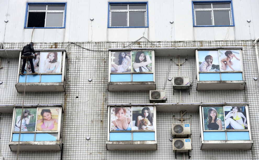 Окна банного комплекса в провинции Хунань, обклеенные фотографиями из интернета