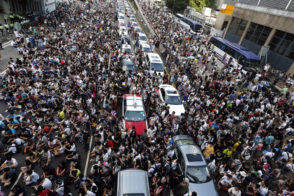 Десятки тысяч демонстрантов блокируют движение на главной дороге, ведущей у Центральному району Гонконга