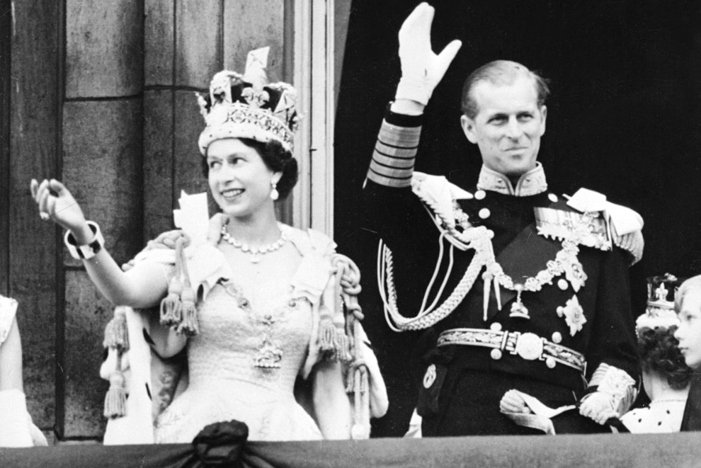 Королева Елизавета II в сопровождении принца Филиппа машет толпе с балкона Букингемского дворца