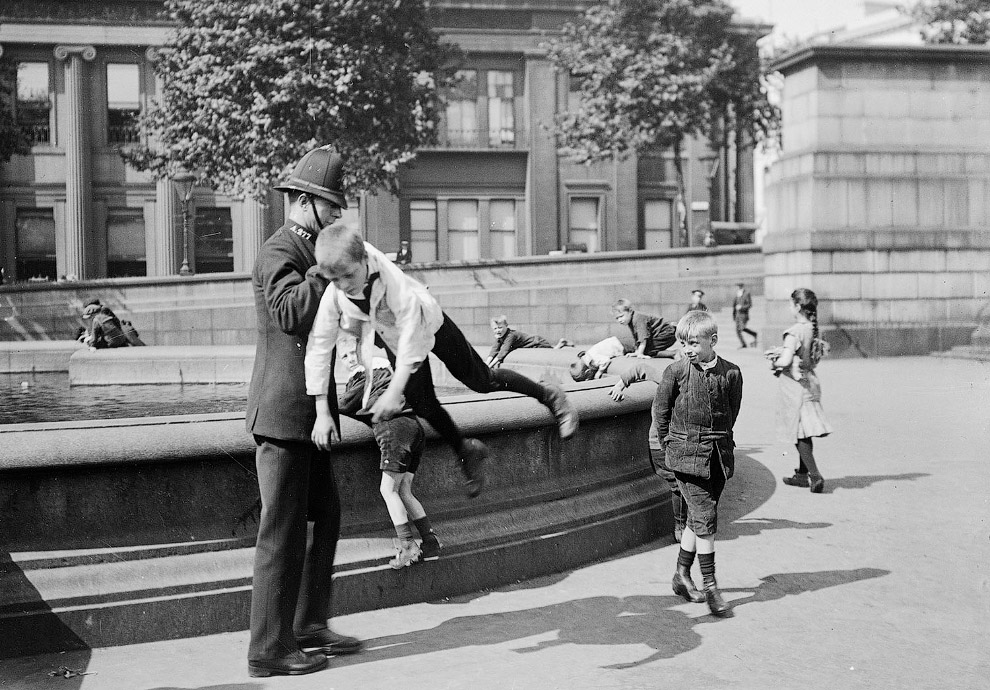 Полицейский задерживает мальчишку на Трафальгарской площади в Лондоне