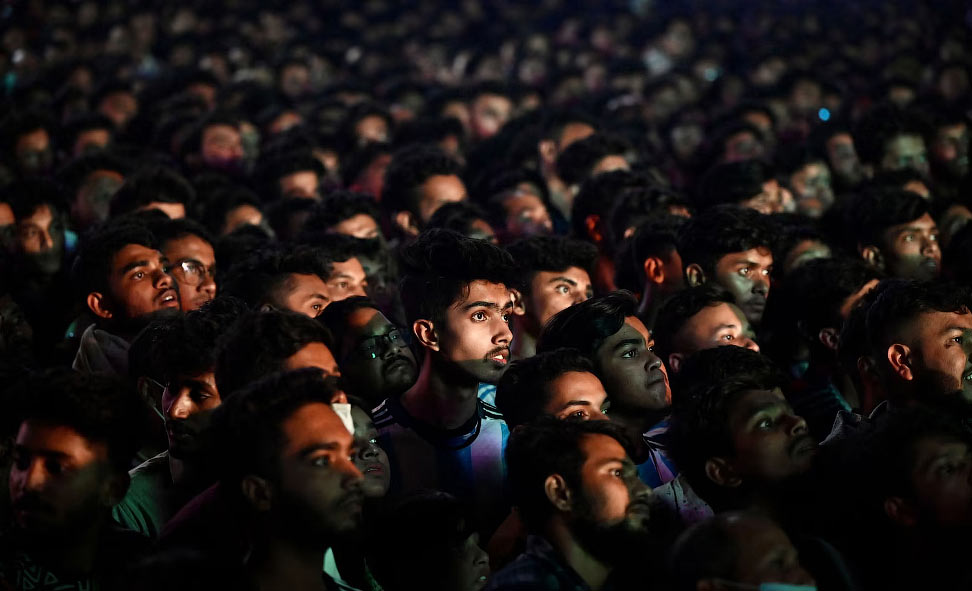 Football fans watch the Qatar 2022 World Cup Group C football match between Poland and Argentina on a big screen, in Dhaka, on December 1, 2022. (Photo by Munir uz zaman / AFP) (Photo by MUNIR UZ ZAMAN/AFP via Getty Images)