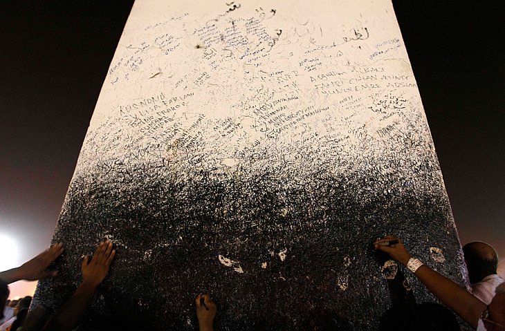 Мусульмане трогают и пишут на колонне Джабал аль-Рама на горе Арафат
