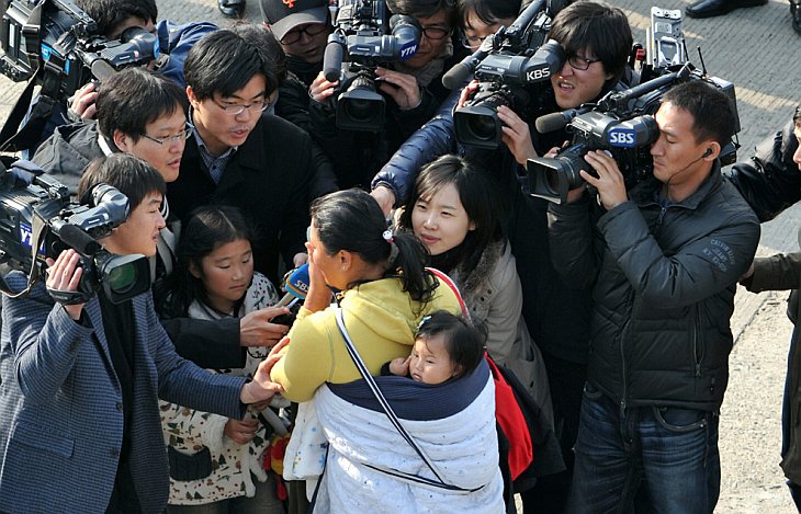 Эвакуированных с острова острова Енпхендо южнокорейских жителей встречают родственники и СМИ