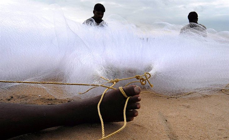 Индийские рыбаки восстанавливают сети, чтобы возобновить рыбалку после тропического шторма «Джал»
