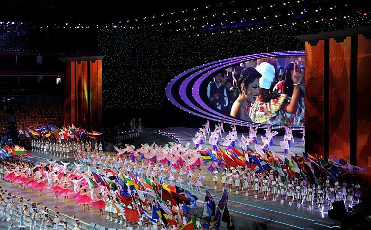 Исполнители махают флагами во время церемонии закрытия World Expo 2010