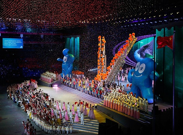 Китайские и иностранные исполнители танцуют на фоне талисмана World Expo 2010