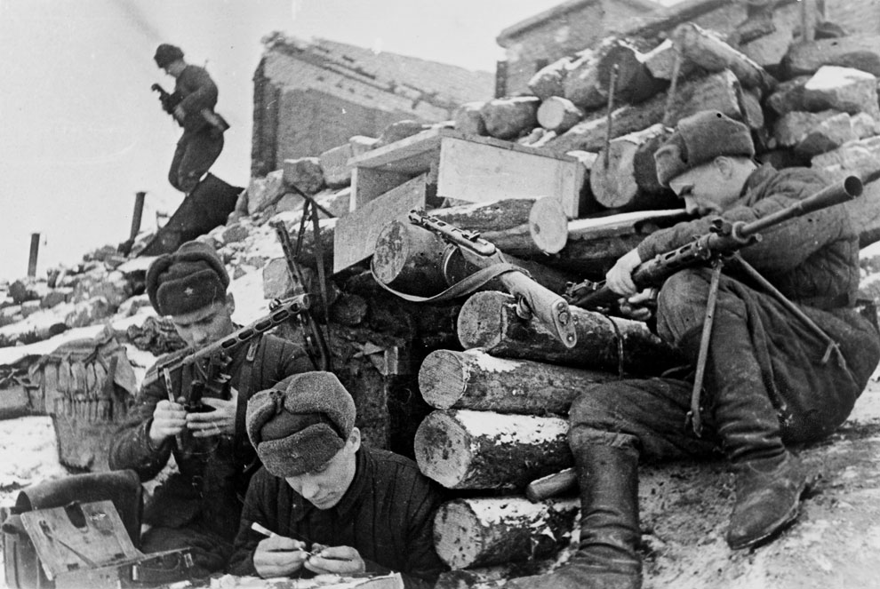Красноармейцы у землянки в Сталинграде заняты чисткой оружия, пистолетов-пулеметов ППШ-41 и пулемета ДП-27