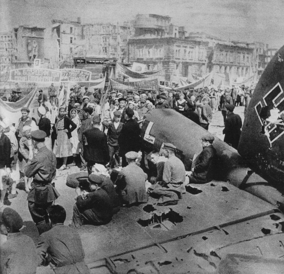 Первомайская демонстрация в разрушенном Сталинграде. На переднем плане хвост сбитого немецкого бомбардировщика Хейнкель He-111