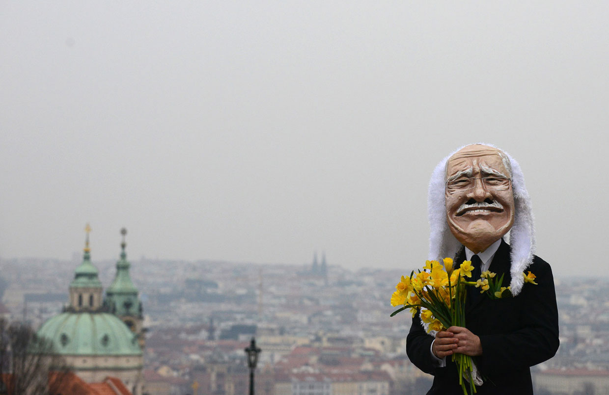 Человек в маске президента Чехии Вацлава Клауса на  Карловом мосту в Праге. Провожает с цветами президента в отставку в день окончания его полномочий