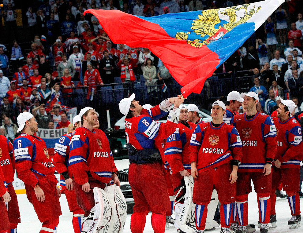Russia's Alexander Ovechkin (C) holds a national flag as he celebrates with his teammates winning their 2012 IIHF men's ice hockey World Championship final game against Slovakia in Helsinki May 20, 2012. REUTERS/Petr Josek (FINLAND - Tags: SPORT ICE HOCKEY) 