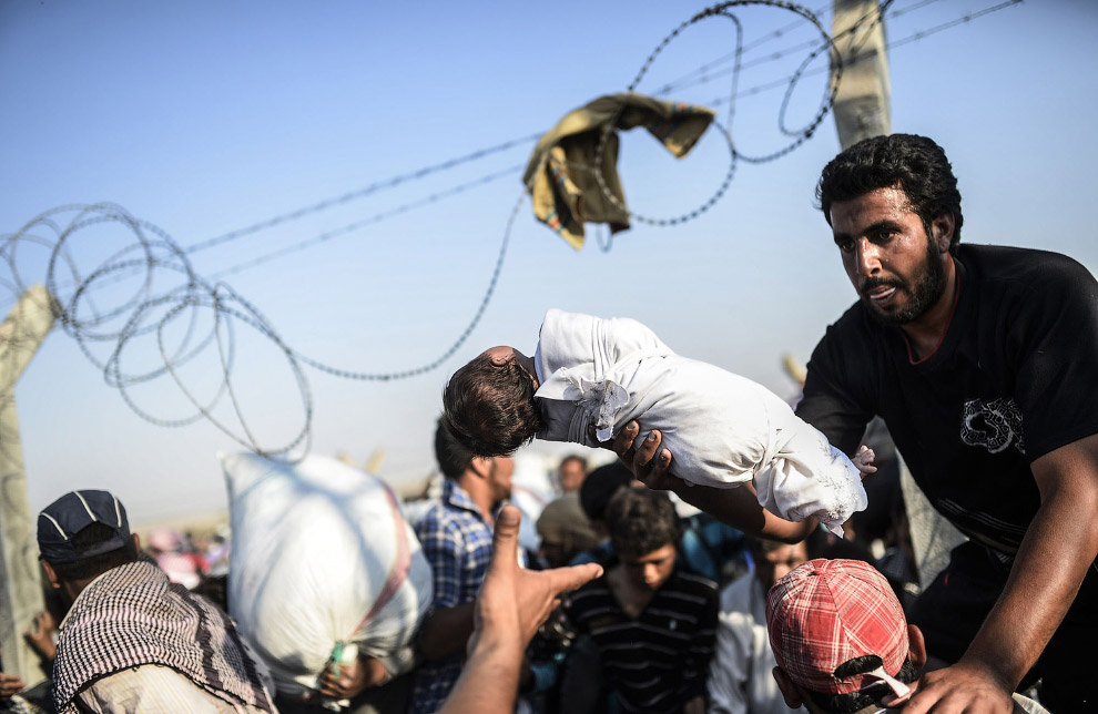 Сирийцы бегут от войны в Турцию, преодолевая пограничный забор
