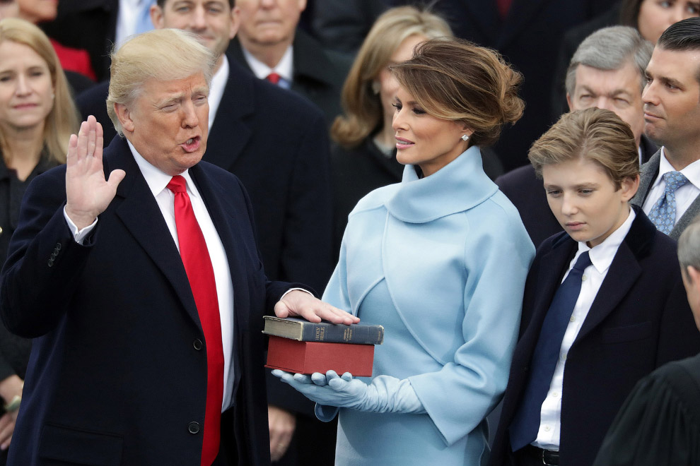 Президент США Дональд Трамп занимает присягу, его жена Мелания держит Библию