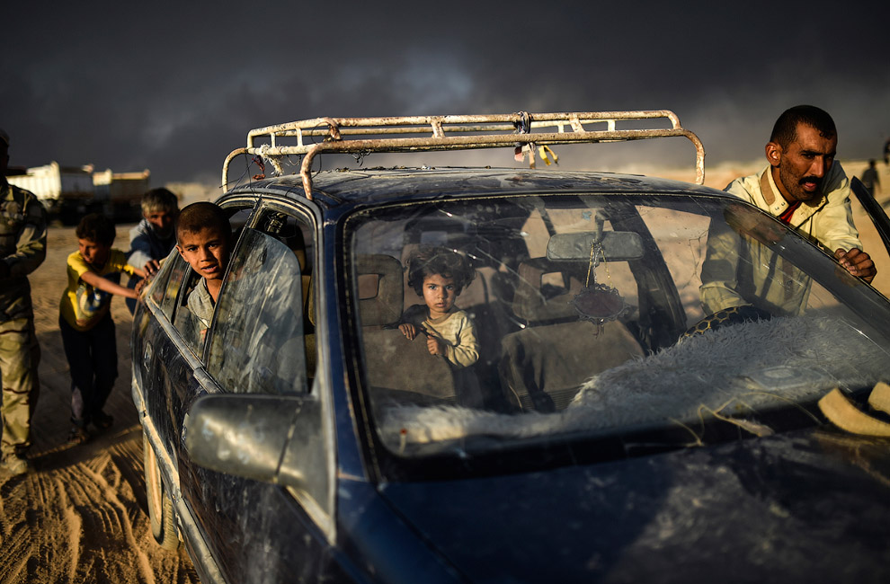 Добрались. Семья толкает заглохшую машину к лагерю беженцев недалеко от Мосула, Ирак