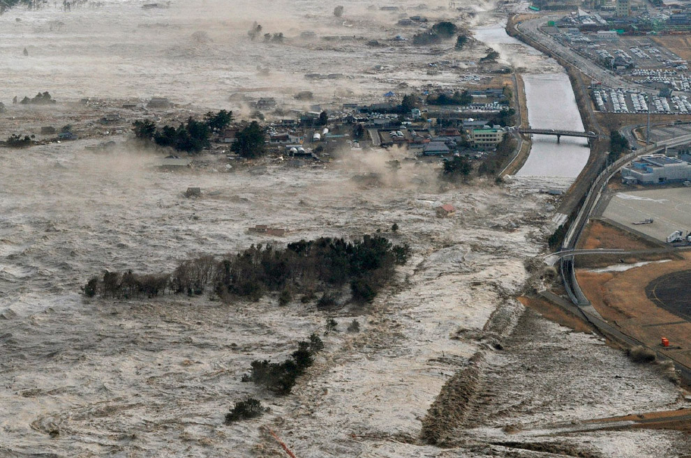 Мощные потоки воды идут вглубь суши в прибрежных районах Иваньума, префектура Мияги
