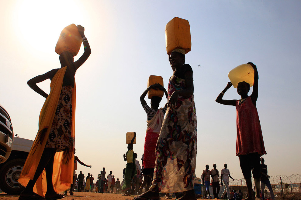 Переноска воды недалеко от столицы Южного Судана. И от солнца спасает