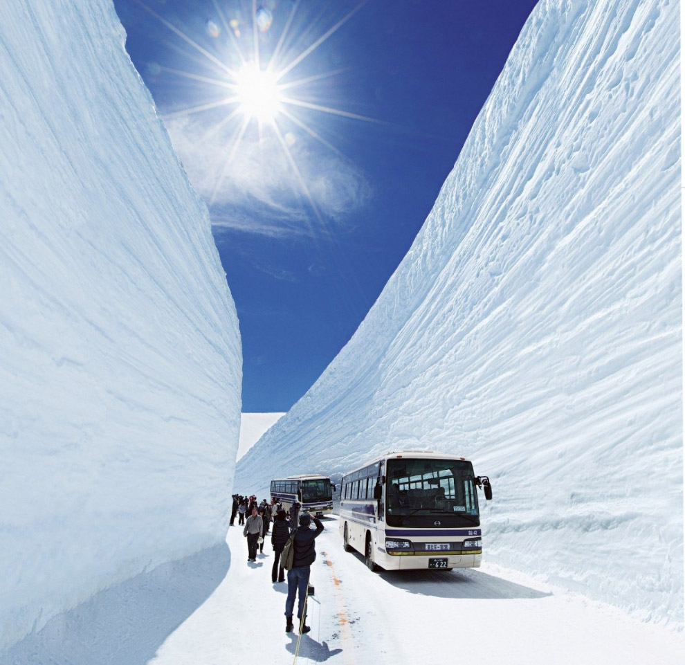TATEYAMA, JAPAN - MAY 10, 2014: Unidentified tourists walk along snow corridor on Tateyama Kurobe Alpine Route, Japanese Alp in Tateyama, Japan
