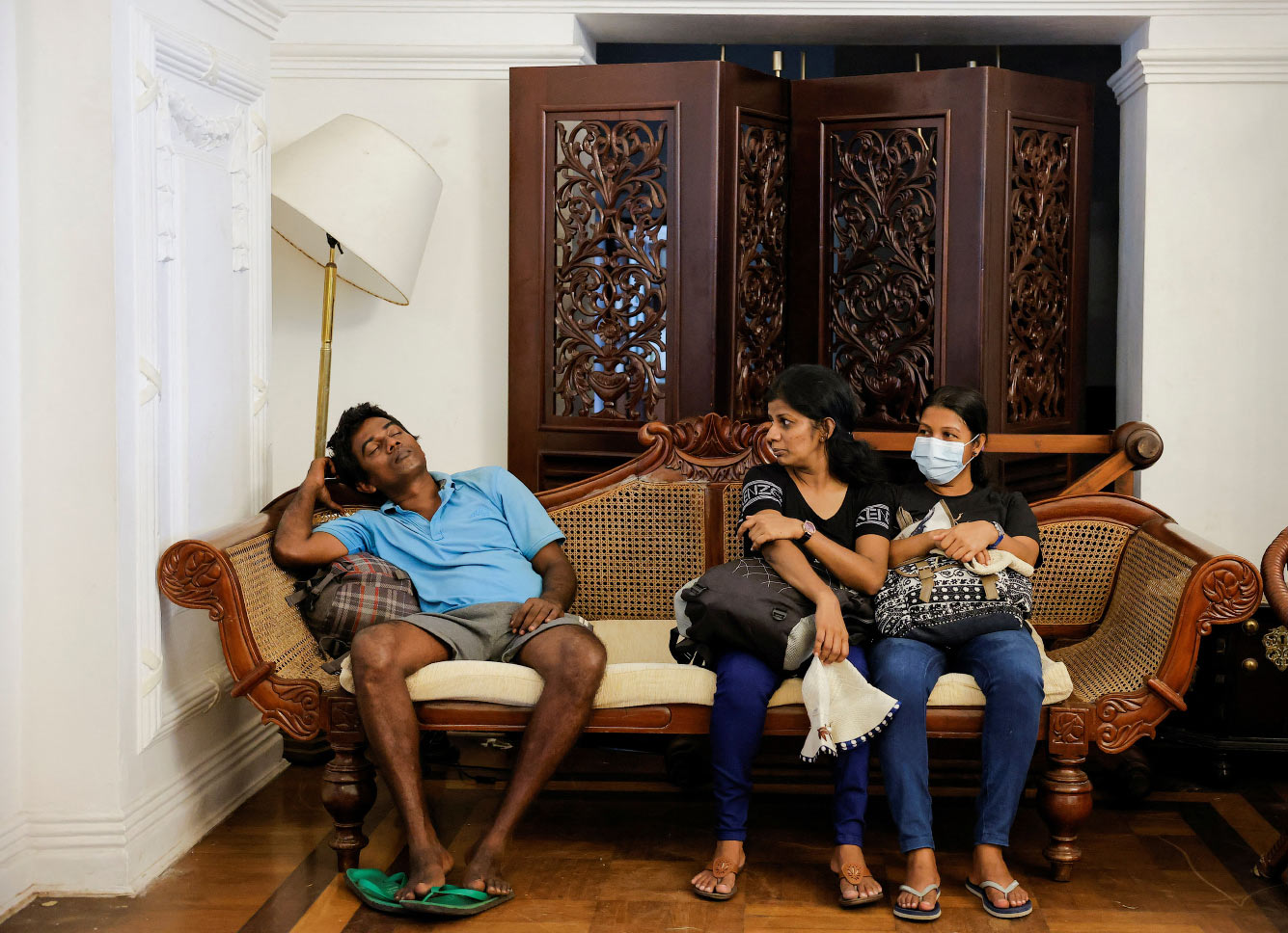 Люди сидят на диване в официальной резиденции премьер-министра Шри-Ланки